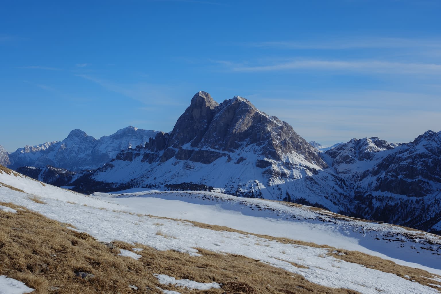 The Peitlerkofel mountain group in winter with white snow and a bright blue sky
