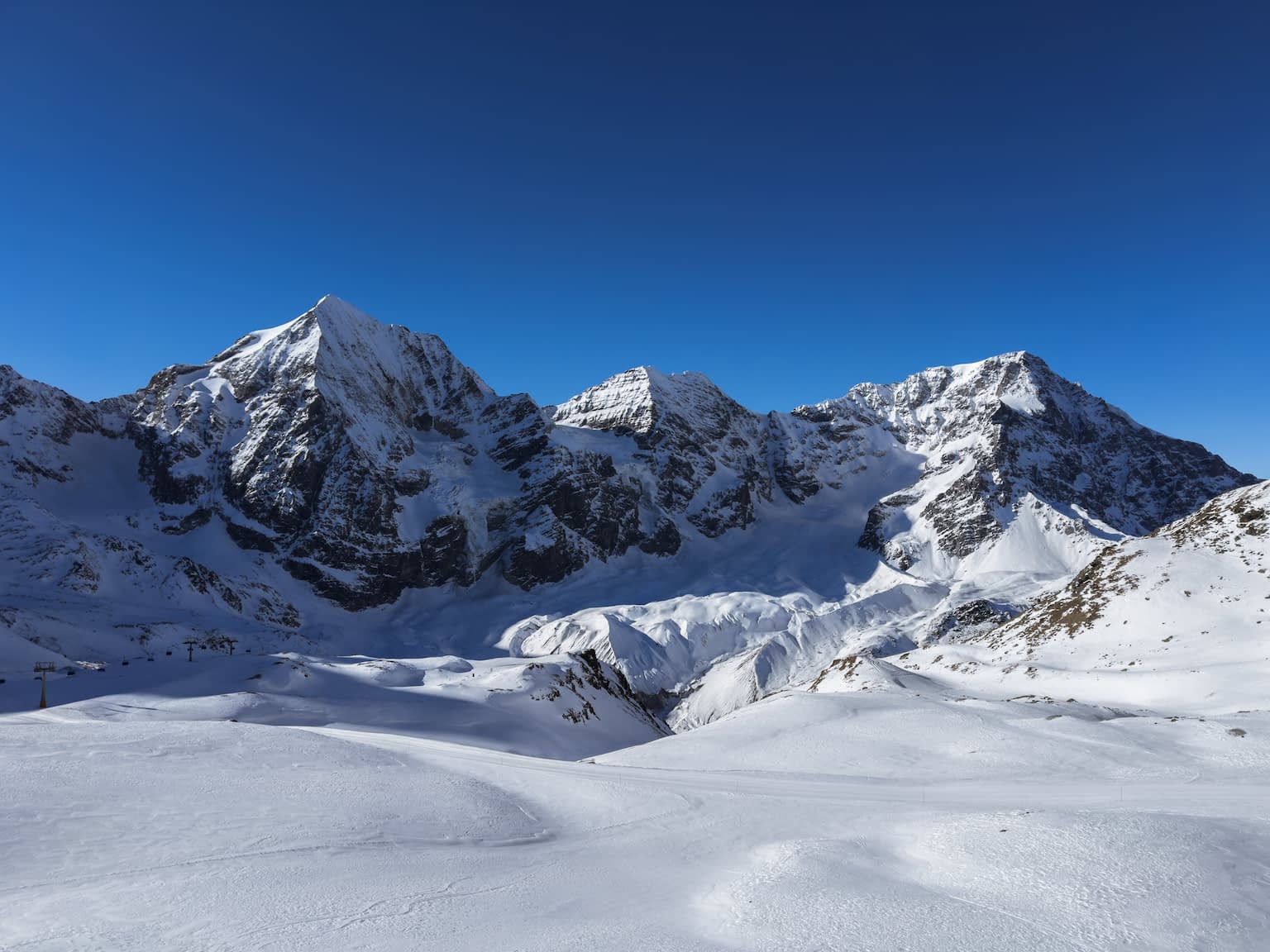 The three mountain peeks Königspitze, Monte Zebrù & Ortler in winter with a clear blue sky.