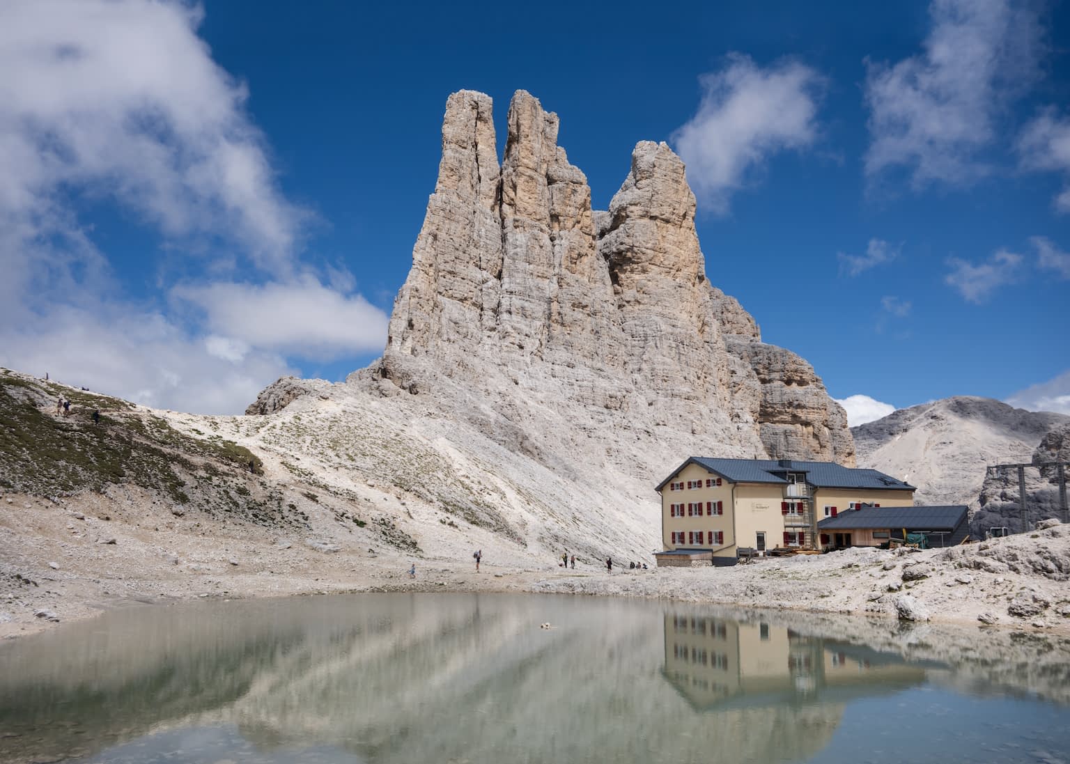 The Vajolet towers brightly illuminated with the Gartlhütte in front.